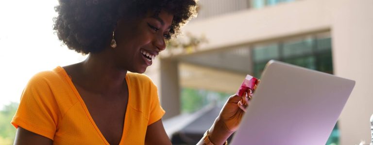 happy-young-african-woman-holding-credit-card-whil-2023-11-27-05-08-05-utc